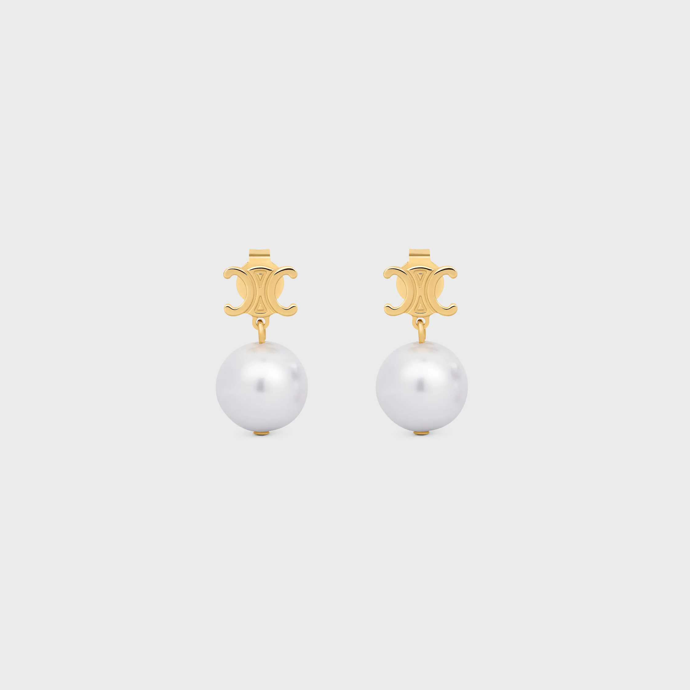 Les boucles d'oreilles Celine en laiton avec finition or et perles en résine