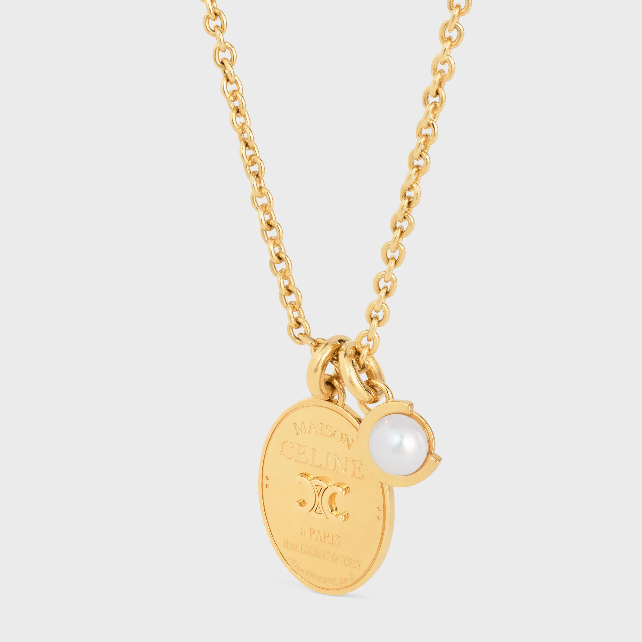 Le collier médaille Celine en perle de résine et laiton avec finition or